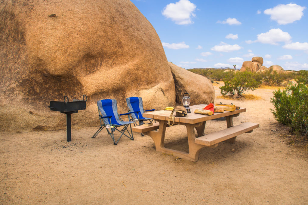 A picnic table and camp chairs in the desert.