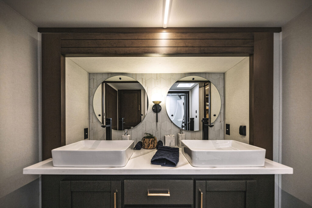 Bathroom interior of the 2025 Heartland RV Bighorn 391MFB Fifth Wheel featuring a modern vanity and sink.