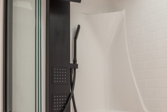Shower head and interior of the bathroom in the 2025 Heartland RV Bighorn 391MFB Fifth Wheel.