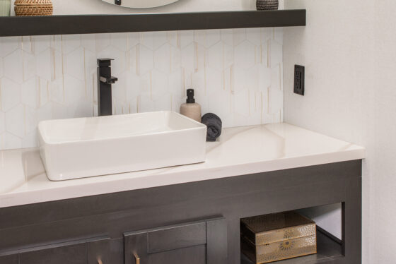Half bathroom inside the 2025 Heartland RV Bighorn 391MFB Fifth Wheel with a modern vanity, sink, and toilet.