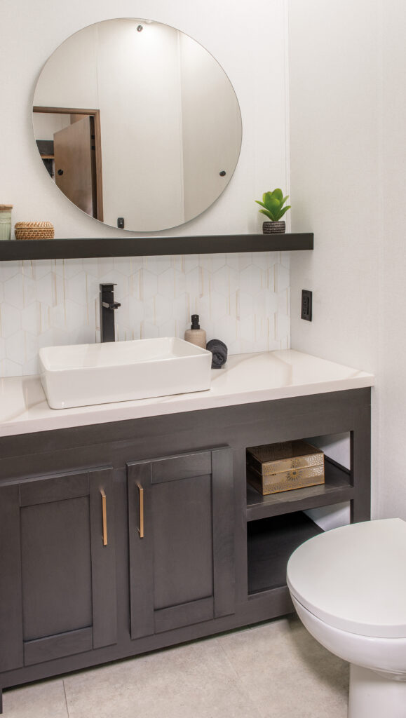 Half bathroom inside the 2025 Heartland RV Bighorn 391MFB Fifth Wheel with a modern vanity, sink, and toilet.