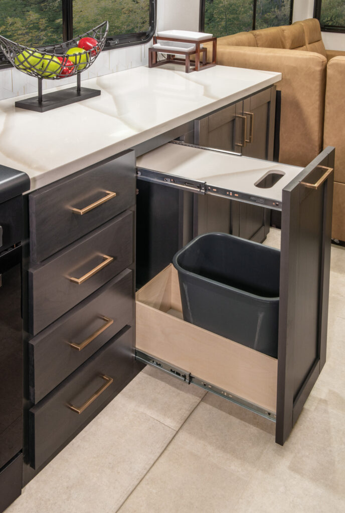 Interior of the 2025 Heartland RV Bighorn 391MFB Fifth Wheel kitchen with a cutting board integrated into the countertop.