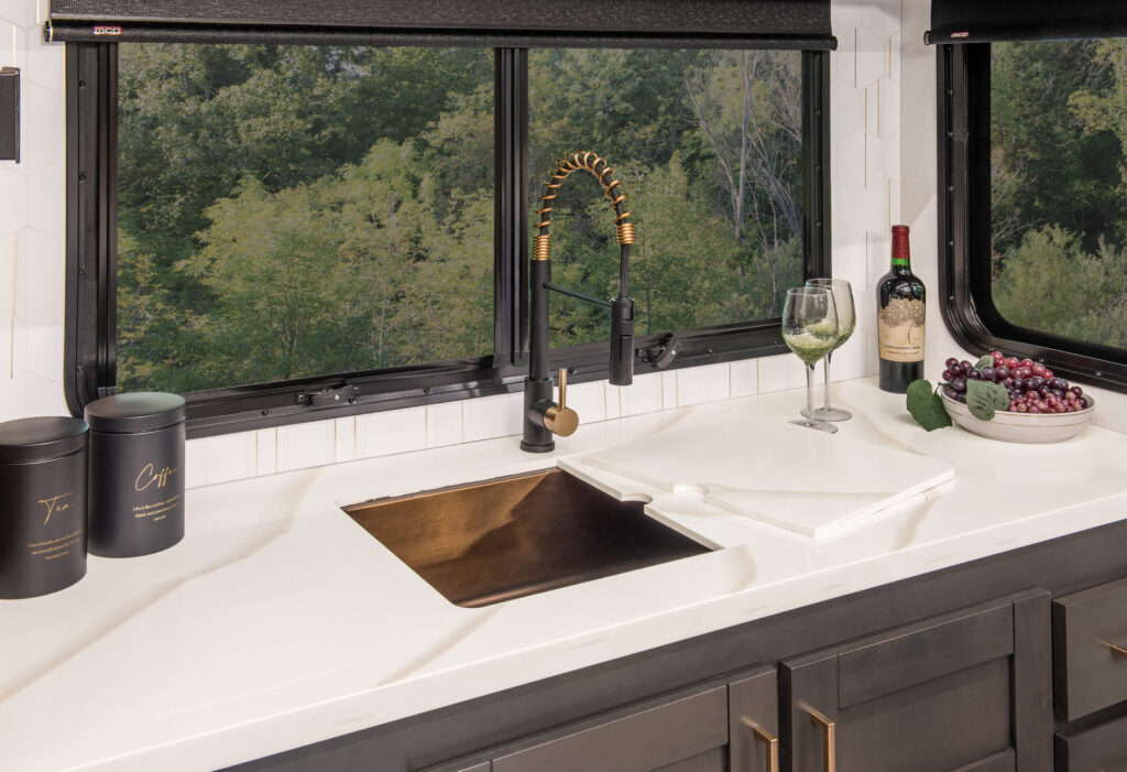 Interior view of the 2025 Heartland RV Bighorn 391MFB Fifth Wheel kitchen showing the kitchen sink with a half-open cabinet below.