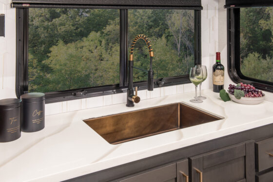 Interior of the 2025 Heartland RV Bighorn 391MFB Fifth Wheel showing the kitchen sink with open cabinetry beneath.