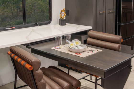 Interior of the 2025 Heartland RV Bighorn 391MFB Fifth Wheel, showcasing a kitchen with a swing-out desk.