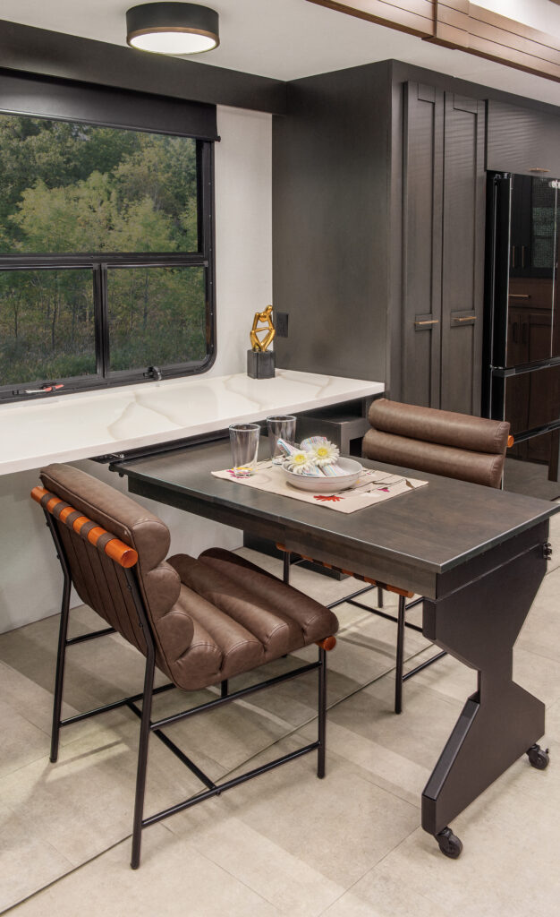 Interior of the 2025 Heartland RV Bighorn 391MFB Fifth Wheel, showcasing a kitchen with a swing-out desk.