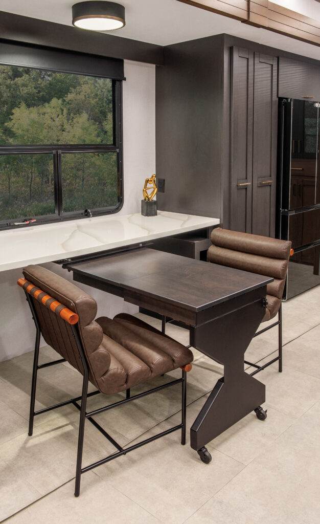 Interior of the 2025 Heartland RV Bighorn 391MFB Fifth Wheel, showcasing a kitchen with a swing-out desk.