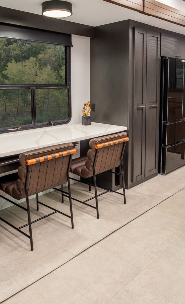 Interior of the 2025 Heartland RV Bighorn 391MFB Fifth Wheel kitchen featuring a swing-out desk and cabinetry.