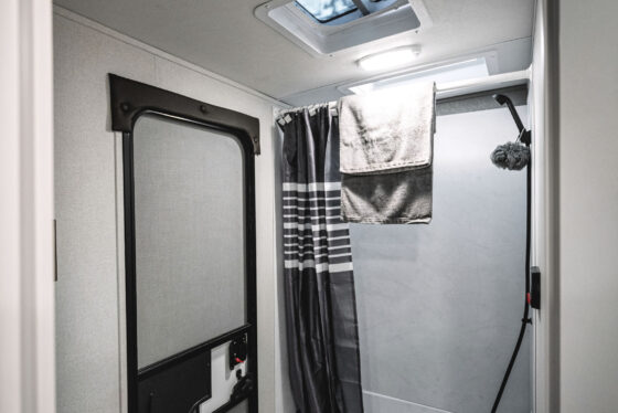 A modern bathroom inside a Heartland RV, featuring a sleek shower and vanity.