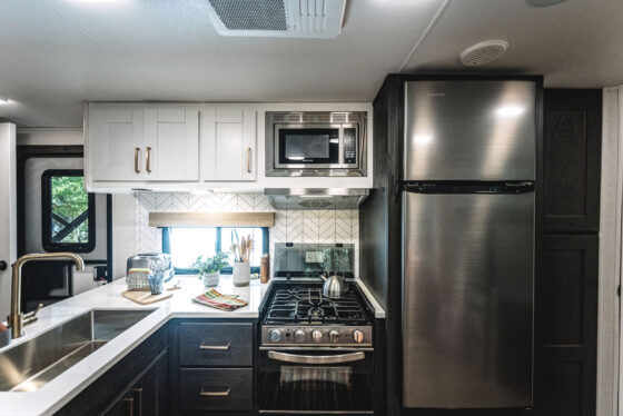 A modern kitchen inside a Heartland RV, featuring stainless steel appliances and ample countertop space.