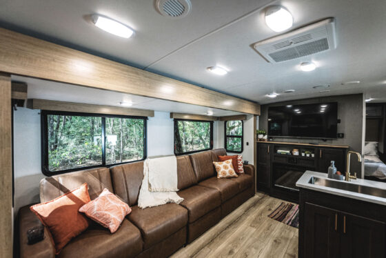 A spacious and modern living area inside a Heartland RV, featuring comfortable seating and decorative accents.