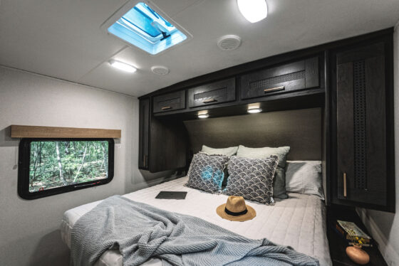 A cozy bedroom inside a Heartland RV, featuring a comfortable bed and stylish decor.