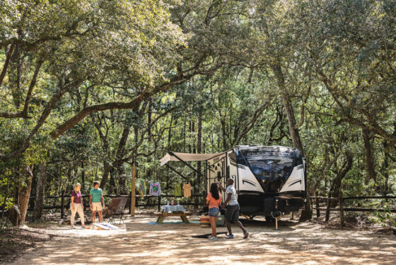 A Heartland North Trail travel trailer parked at a scenic campsite.