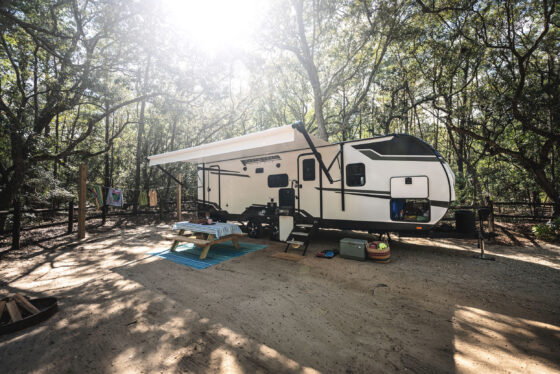 A Heartland North Trail travel trailer parked at a scenic campsite.