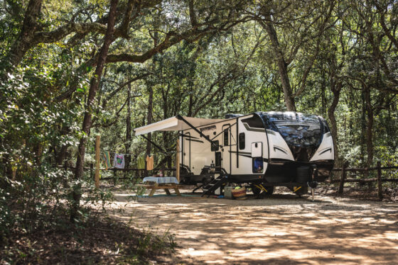 A Heartland North Trail travel trailer parked at a scenic campsite.