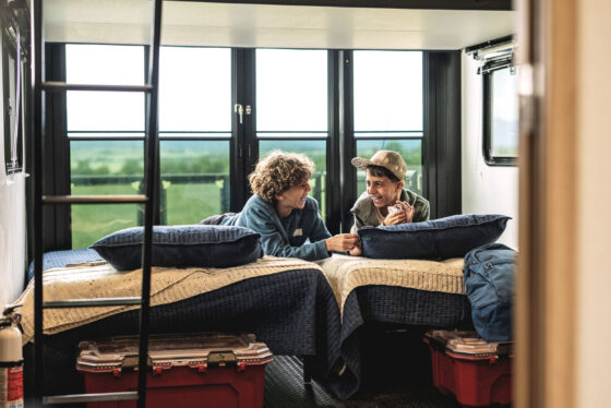 Interior view of a loft in an RV with two beds underneath, offering efficient space for sleeping arrangements.