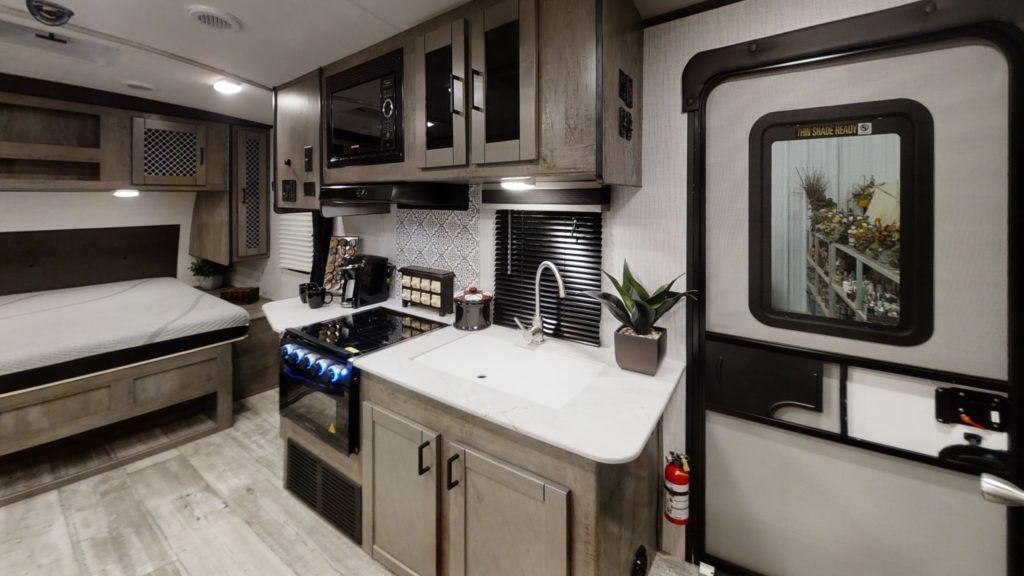 Inside an Ultralight RV, the North Trail 21RBSS model, showing the compact door and kitchen areas.