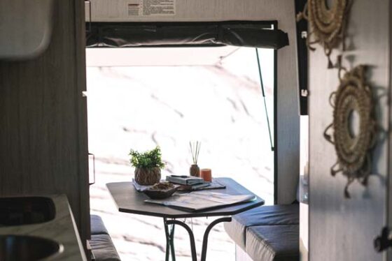 Interior view of the dinette area in a Sundance Ultra Lite travel trailer, featuring a cozy seating area and a convertible dining table.