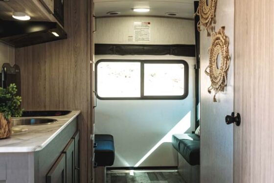 Interior of a modern Sundance 2023 RV, featuring plush seating, a sleek kitchen, and ample natural light