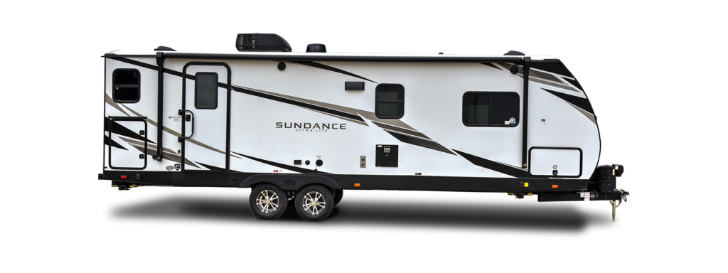 A double-axle Heartland Sundance travel trailer parked in a serene outdoor setting.