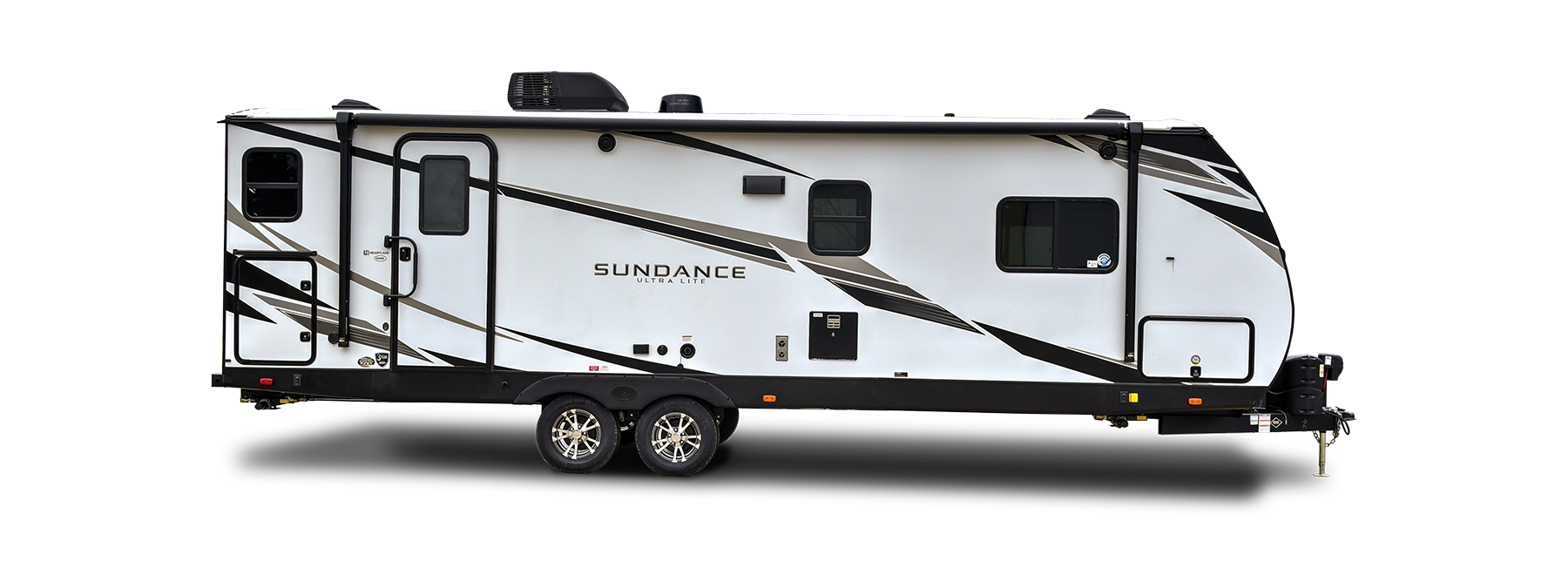 A double-axle Heartland Sundance travel trailer parked in a serene outdoor setting.