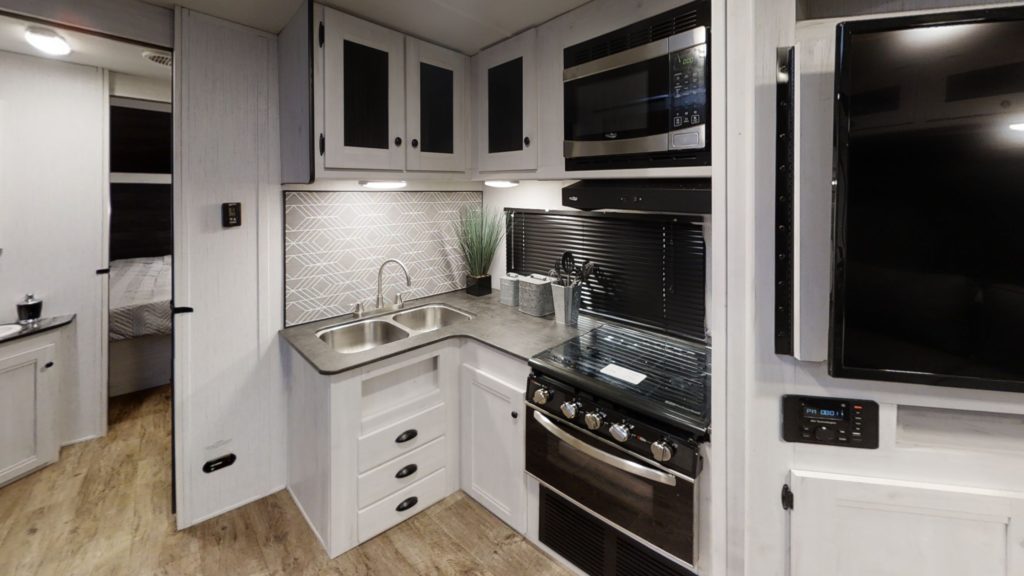 Interior view of the kitchen in the 255RL Trail Runner travel trailer, featuring modern appliances and ample counter space.