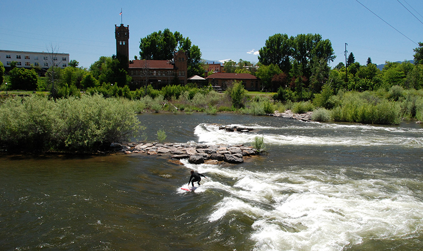 A surfer riding the waves on a river.