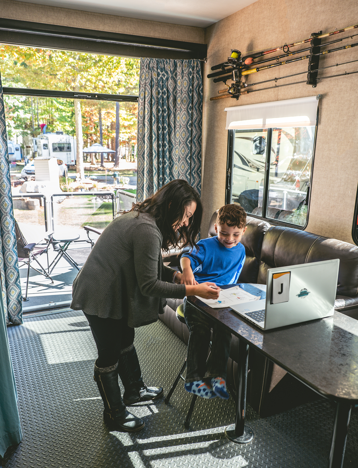 Sandra helping her son do homework in the toy hauler garage space, which has been rearranged to serve as a classroom.