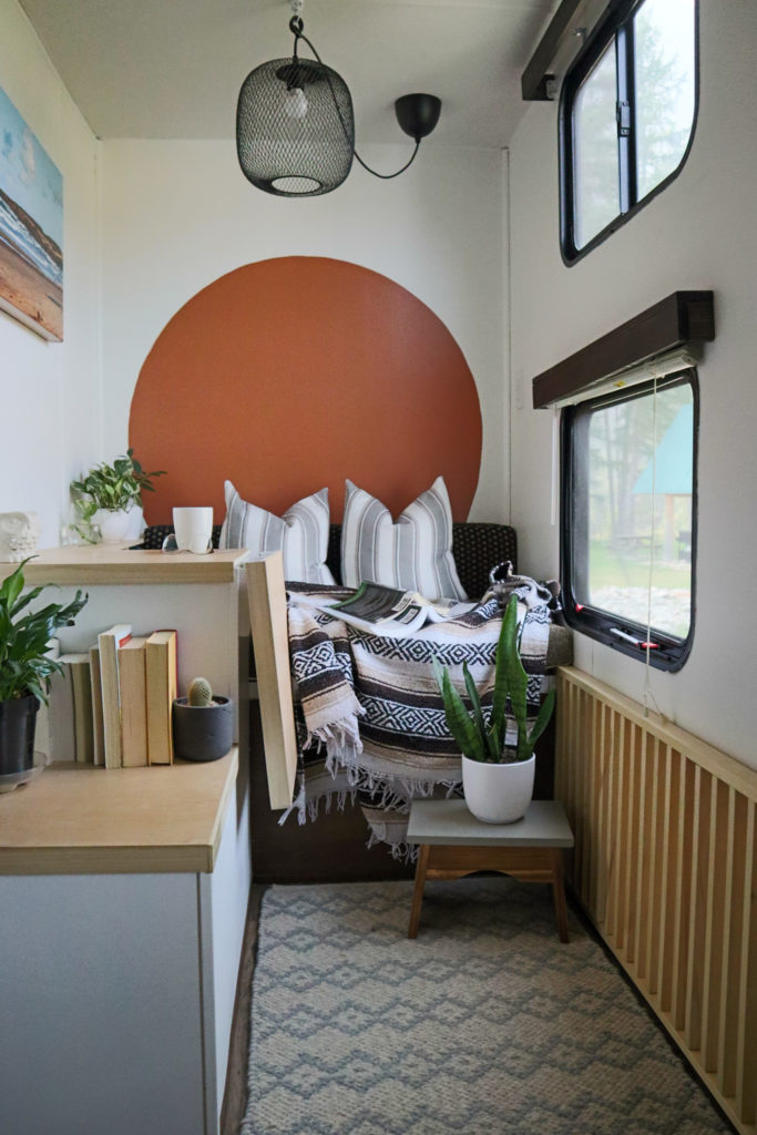 A beautiful, modified RV room with a fold-up desk and cozy bench seating.