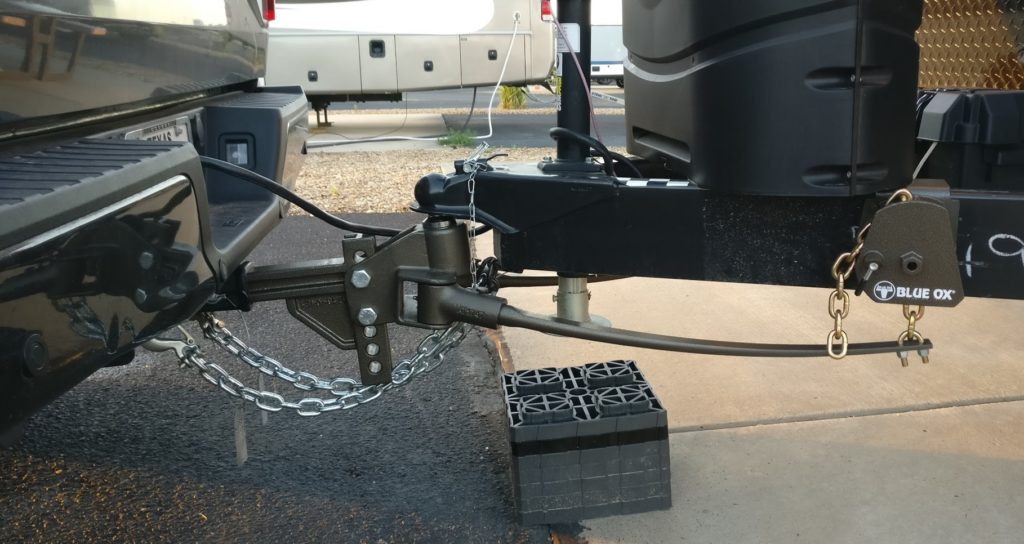 A close up image of a travel trailer hitched to a truck. 