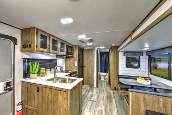 Compact and functional kitchen in a Pioneer travel trailer, featuring modern appliances and ample storage space.