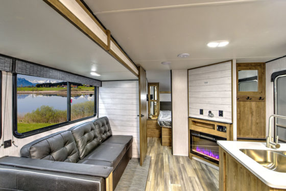 Interior view of the living space in a Pioneer travel trailer, showcasing cozy seating and modern amenities.