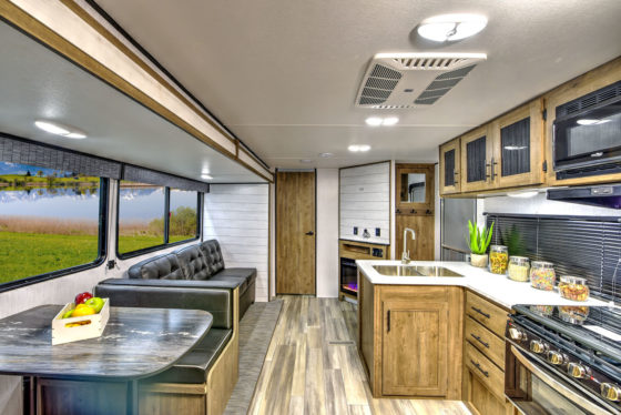 Interior view of the living space in a Pioneer travel trailer, showcasing cozy seating and modern amenities.