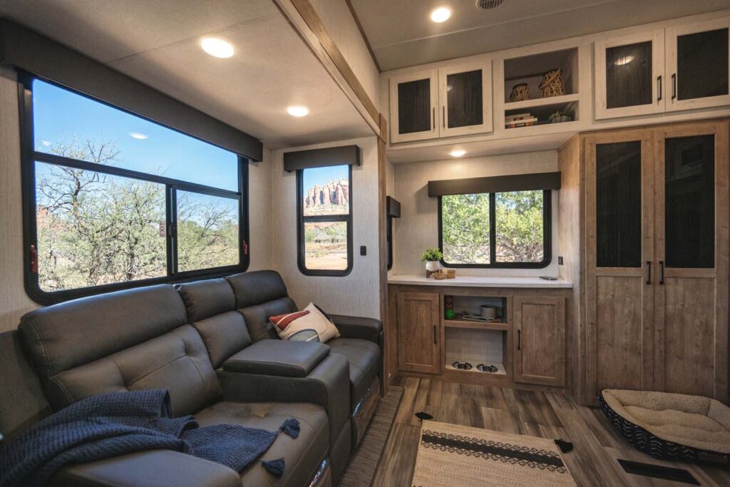 Interior view of the 2025 Heartland RV Bighorn 391MFB Fifth Wheel, featuring a cozy living area with a sofa, large windows, and elegant décor.