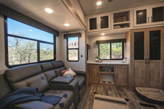 Interior view of the 2025 Heartland RV Bighorn 391MFB Fifth Wheel, featuring a cozy living area with a sofa, large windows, and elegant décor.