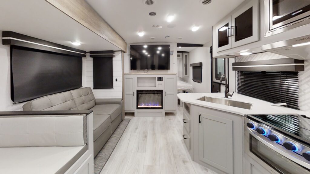 A well-lit kitchen inside a Heartland RV North Trail 27BHG model, showcasing modern appliances and ample countertop space.