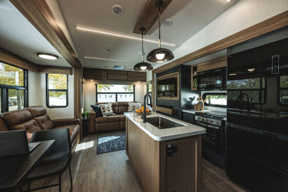 Interior view of the Heartland Corterra fifth-wheel RV, showcasing the spacious living area with modern furniture, large windows, and high-end finishes.