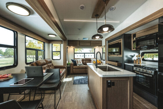 Interior view of the Heartland Corterra fifth-wheel RV, showcasing the spacious living area with modern furniture, large windows, and high-end finishes.