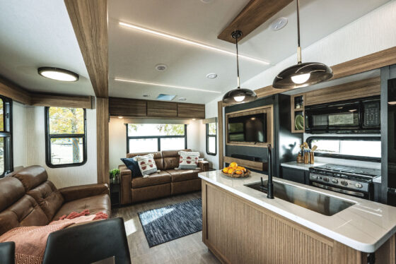 Interior view of the Heartland Corterra fifth-wheel RV, showcasing a modern living space with comfortable seating, large windows, and stylish finishes.