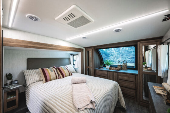 Interior of the Heartland Corterra fifth-wheel RV bedroom, featuring a large bed, modern furnishings, and ample storage space.