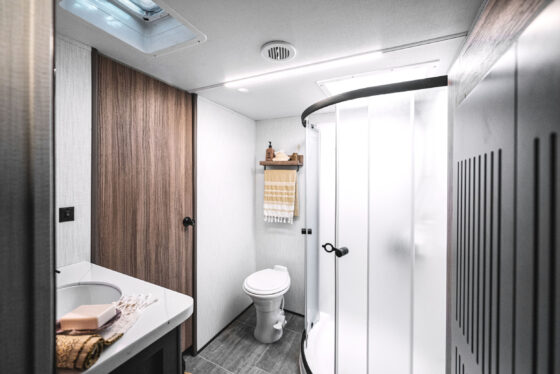 Interior view of the bathroom in the 2024 Heartland Corterra fifth-wheel RV, featuring a spacious shower, modern fixtures, and elegant finishes.
