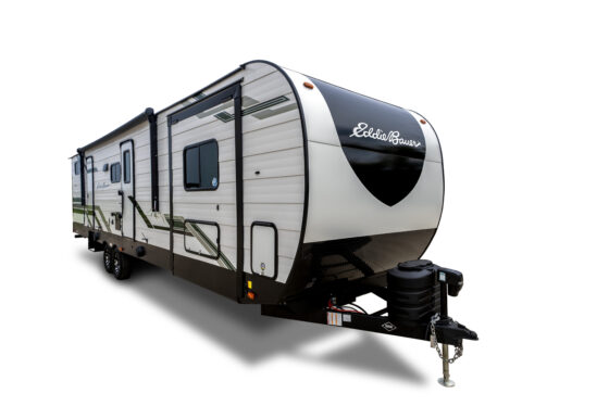 A white and black travel trailer with green accents, two axles, a side door, and the name “Eddie Bauer” on the front, shown on a white background.