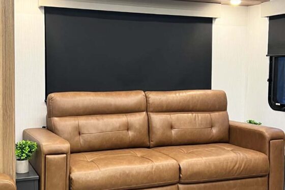 Close-up of the living room couch inside the Heartland Corterra fifth-wheel RV, featuring comfortable seating with stylish cushions and fabric.