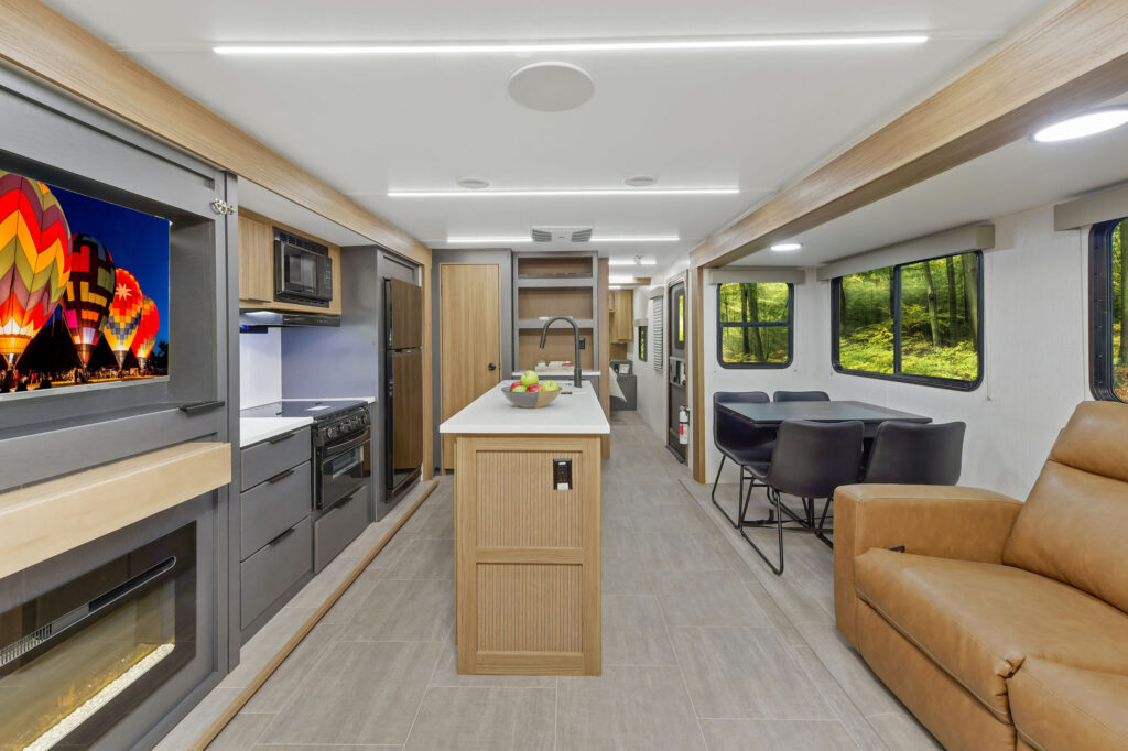 Interior of the 2024 Heartland Cyclone 30.3RL Fifth Wheel Toy Hauler living area, featuring cozy seating, modern décor, and a large entertainment center.