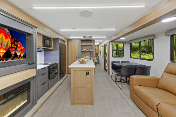 Interior of the 2024 Heartland Cyclone 30.3RL Fifth Wheel Toy Hauler living area, featuring cozy seating, modern décor, and a large entertainment center.