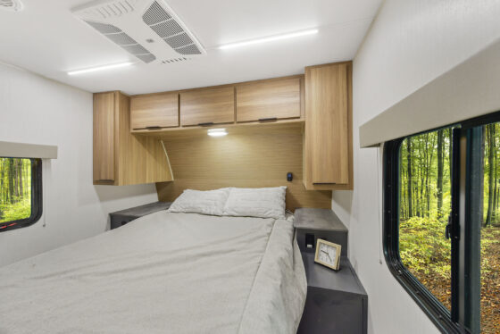Interior view of the 2024 Heartland Cyclone CT 30.3RL Fifth Wheel Toy Hauler bedroom, featuring a queen-sized bed, stylish cabinetry, and modern décor.