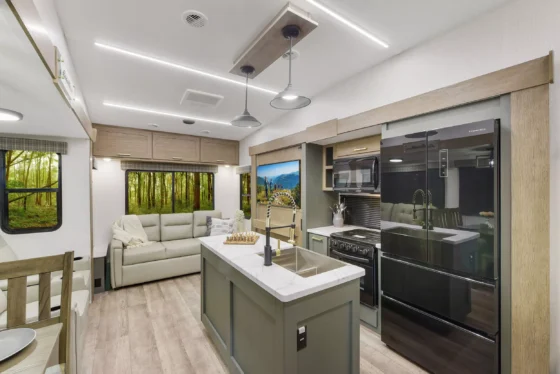 Fully equipped kitchen inside the 2024 Heartland Eddie Bauer 3100RL, featuring a center island, stainless steel appliances, and ample storage cabinets.
