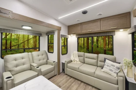 Interior of the 2024 Heartland Eddie Bauer 3100RL, showcasing a spacious living area with theater seating, a sofa, an entertainment center.