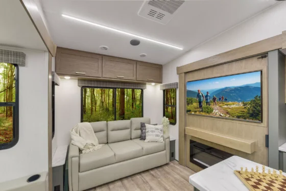 Interior of the 2024 Heartland Eddie Bauer 3100RL, showcasing a spacious living area with plush seating, a modern kitchen, and elegant design features.