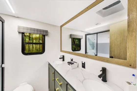 Dual-sink vanity in the 2024 Heartland Eddie Bauer 3100RL bathroom, featuring modern fixtures and ample counter space.